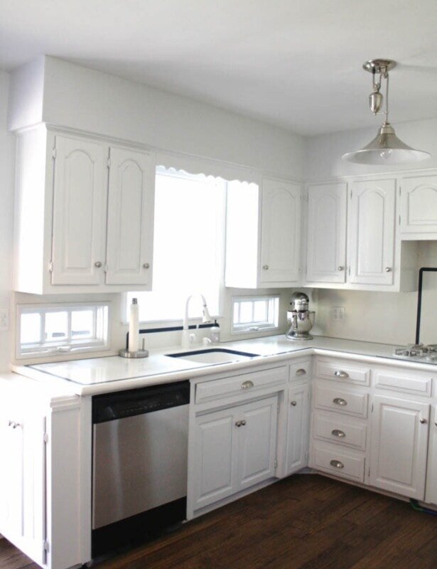 有木地板和不锈钢用具的白色厨房。