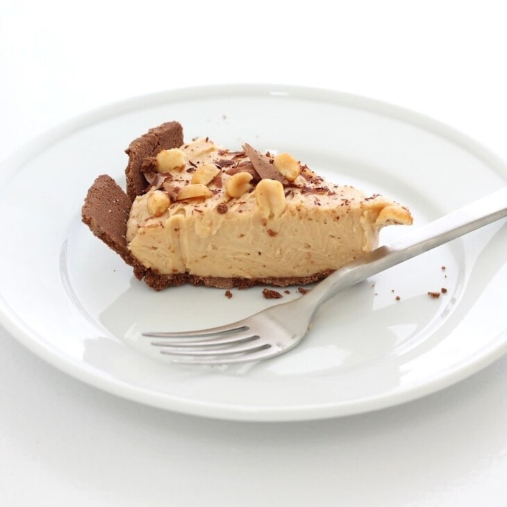 用叉子将花生酱和巧克力芝士蛋糕片放在白色盘子上gydF4y2Ba