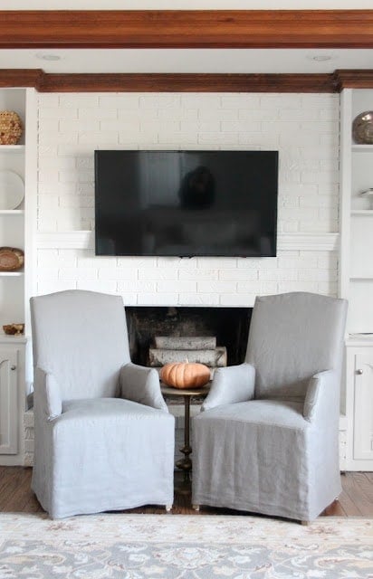 一个带有两把灰色椅子的客厅，上面有电视