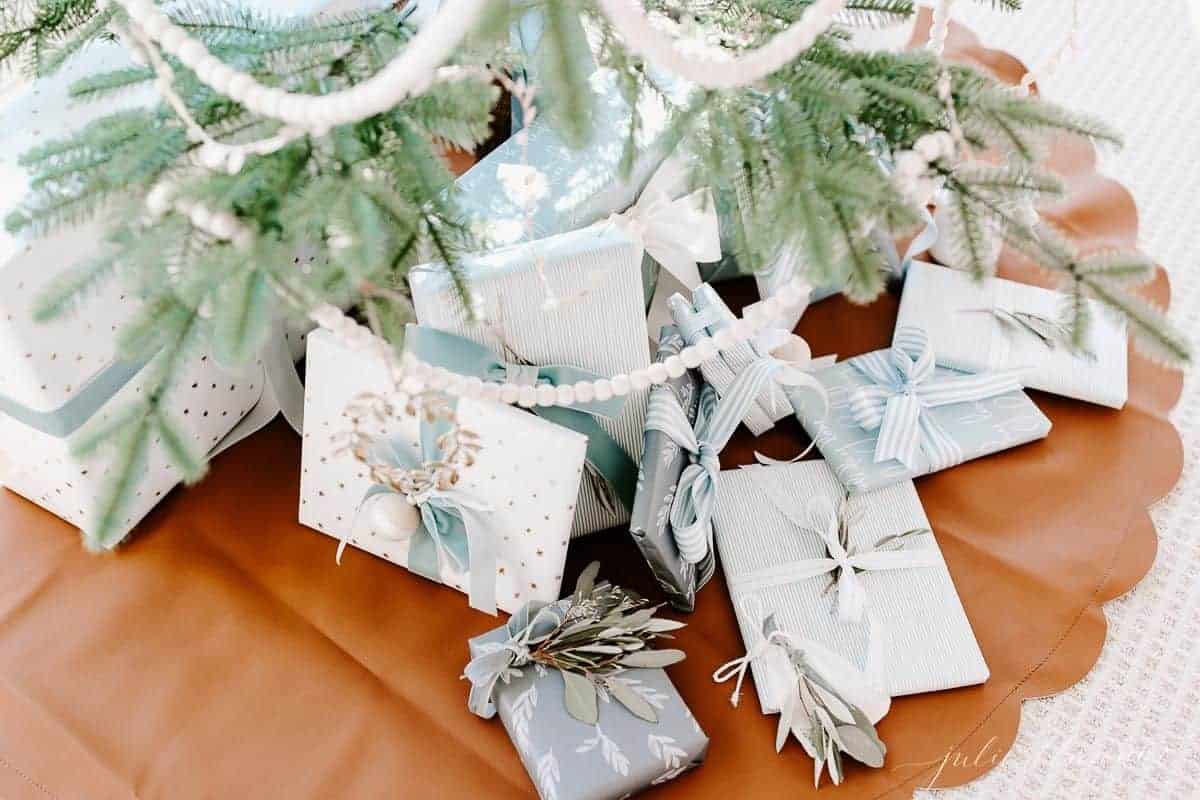 蓝色和白色包裹的圣诞礼物包裹在树下。