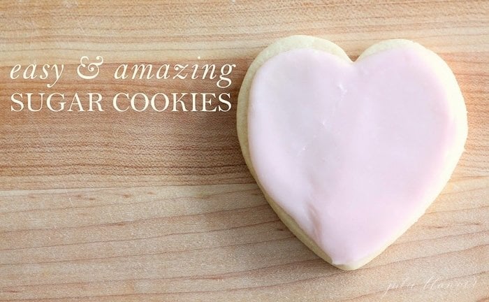 心形的糖果饼干，表面是木制的，上面有粉红色的糖霜。简单和惊人的白色文字覆盖糖饼干。gydF4y2Ba