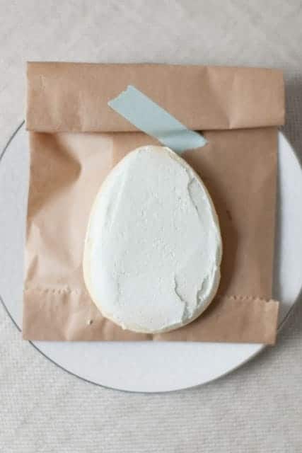 鸡蛋形状的白糖饼干，放在棕色的纸袋上。gydF4y2Ba