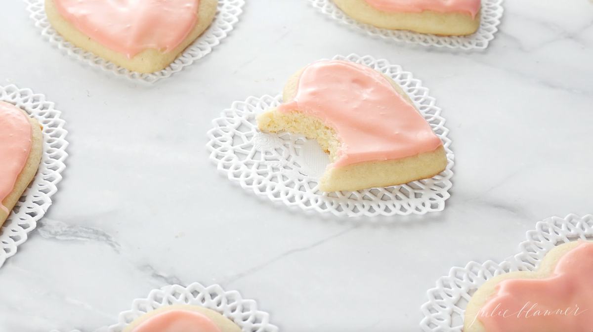 粉色心形糖饼干放在大理石表面，心形纸垫上。gydF4y2Ba