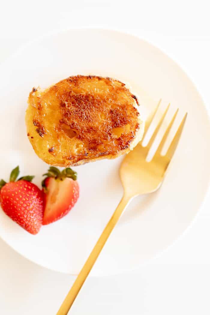 切片在白色板材的奶油奶油法国多士用金叉子和草莓GydF4y2Ba