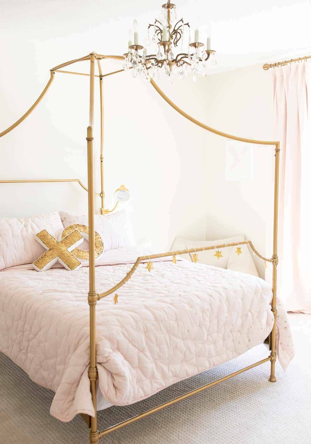 这是一间少女卧室，有一张金色的床和一张白色的桌子，还有粉红色的被褥