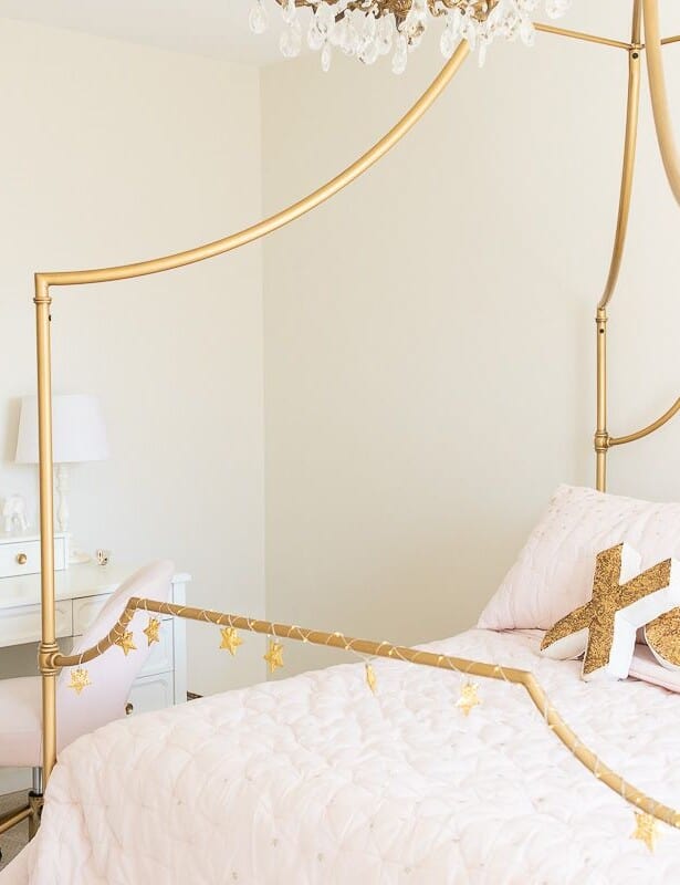 一个补间女孩卧室，带有金床和一张白色的桌子，脸红粉红色的床上用品