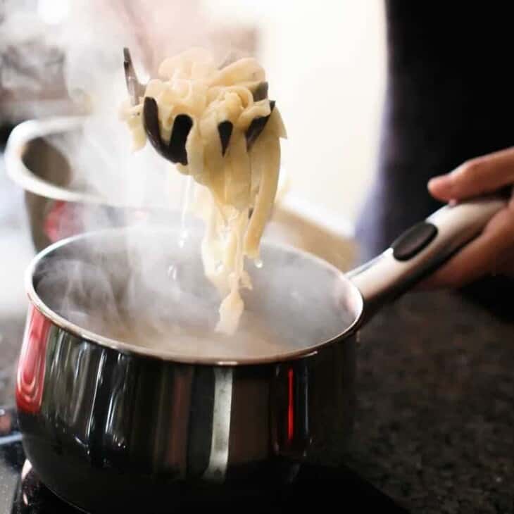 用意大利面勺从沸水锅中取出自制的意大利面gydF4y2Ba