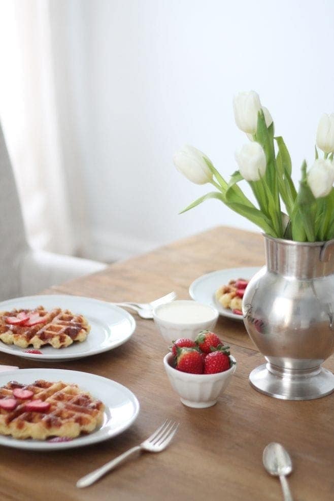 自制的比利时华夫饼放在白盘子里，草莓和木桌上的植物gydF4y2Ba