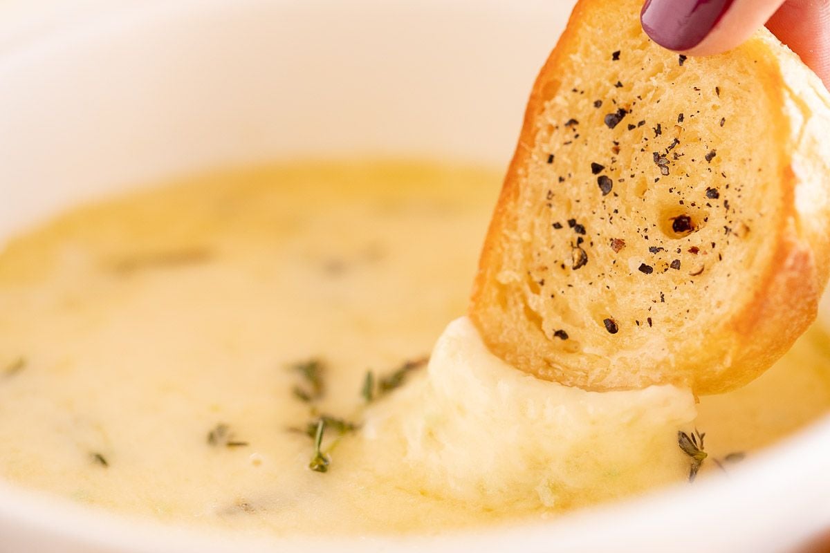 大蒜热奶酪蘸酱从白色碗里伸出来