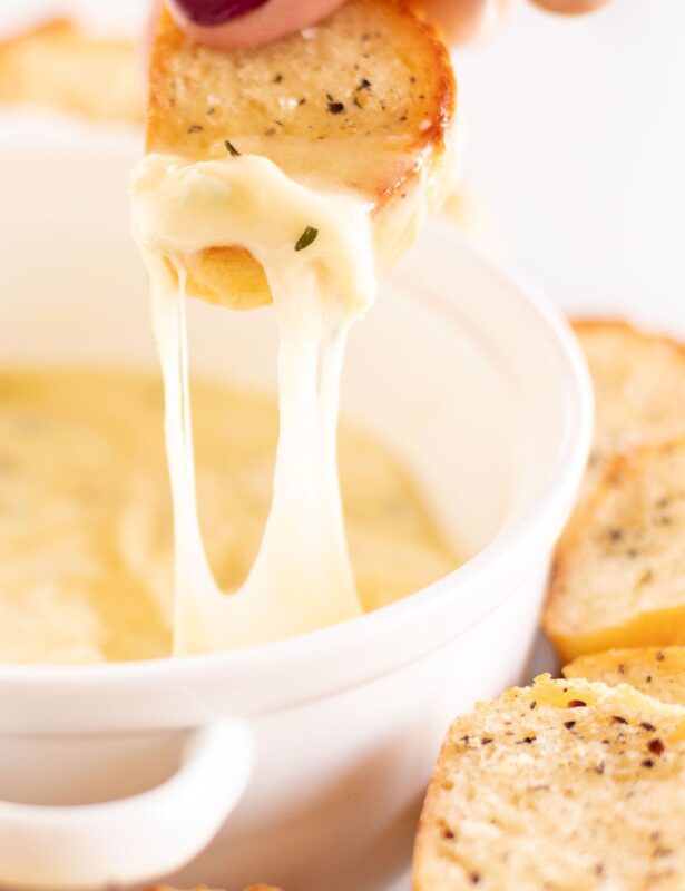 热的大蒜乳酪蘸伸出一个白色碗