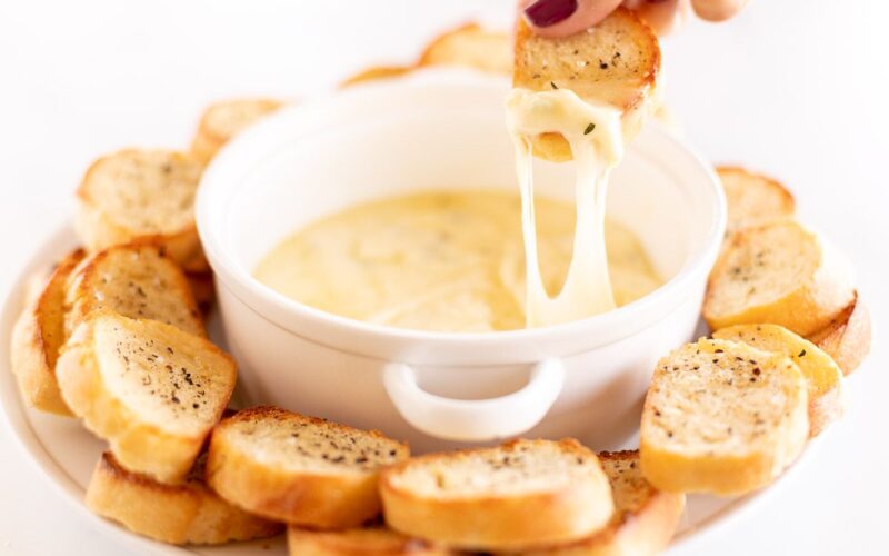 热大蒜奶酪蘸从白碗伸出