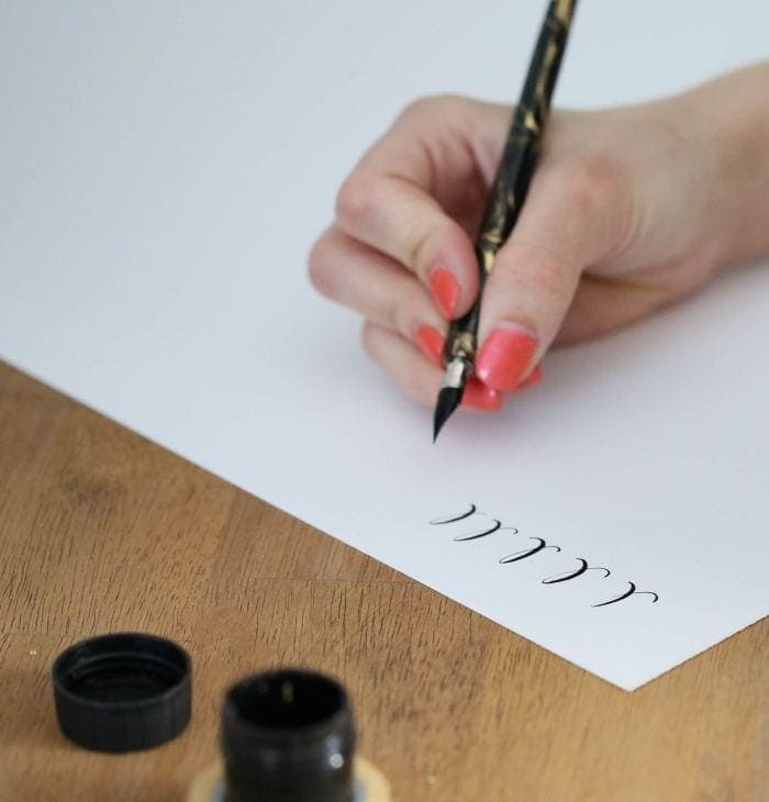 一个女人练习书法字母表。
