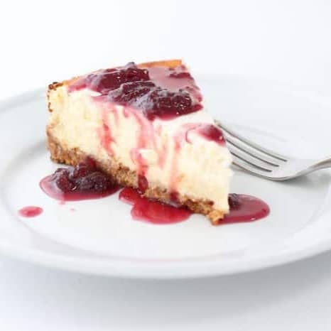 一块芝士蛋糕放在白盘子上，上面放一层草莓芝士蛋糕。