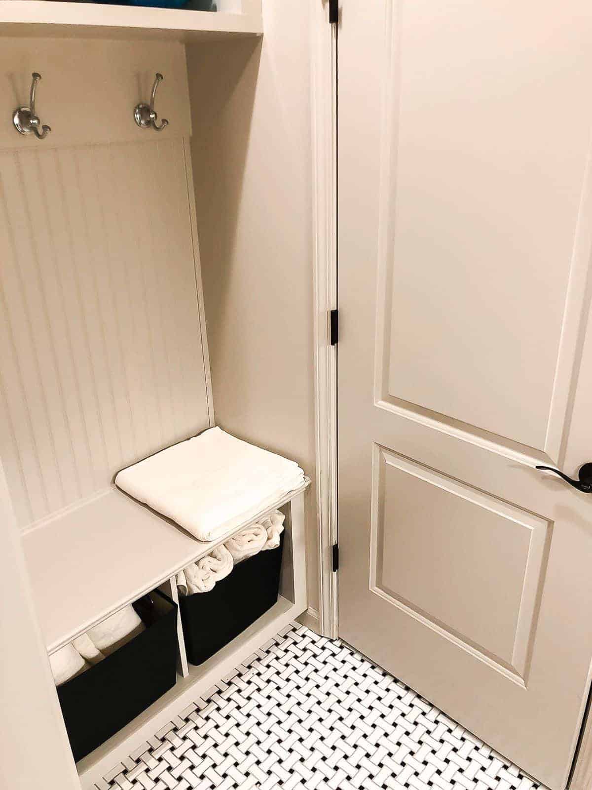 SW无障碍米色小浴室，内置橱柜和黑白地板。