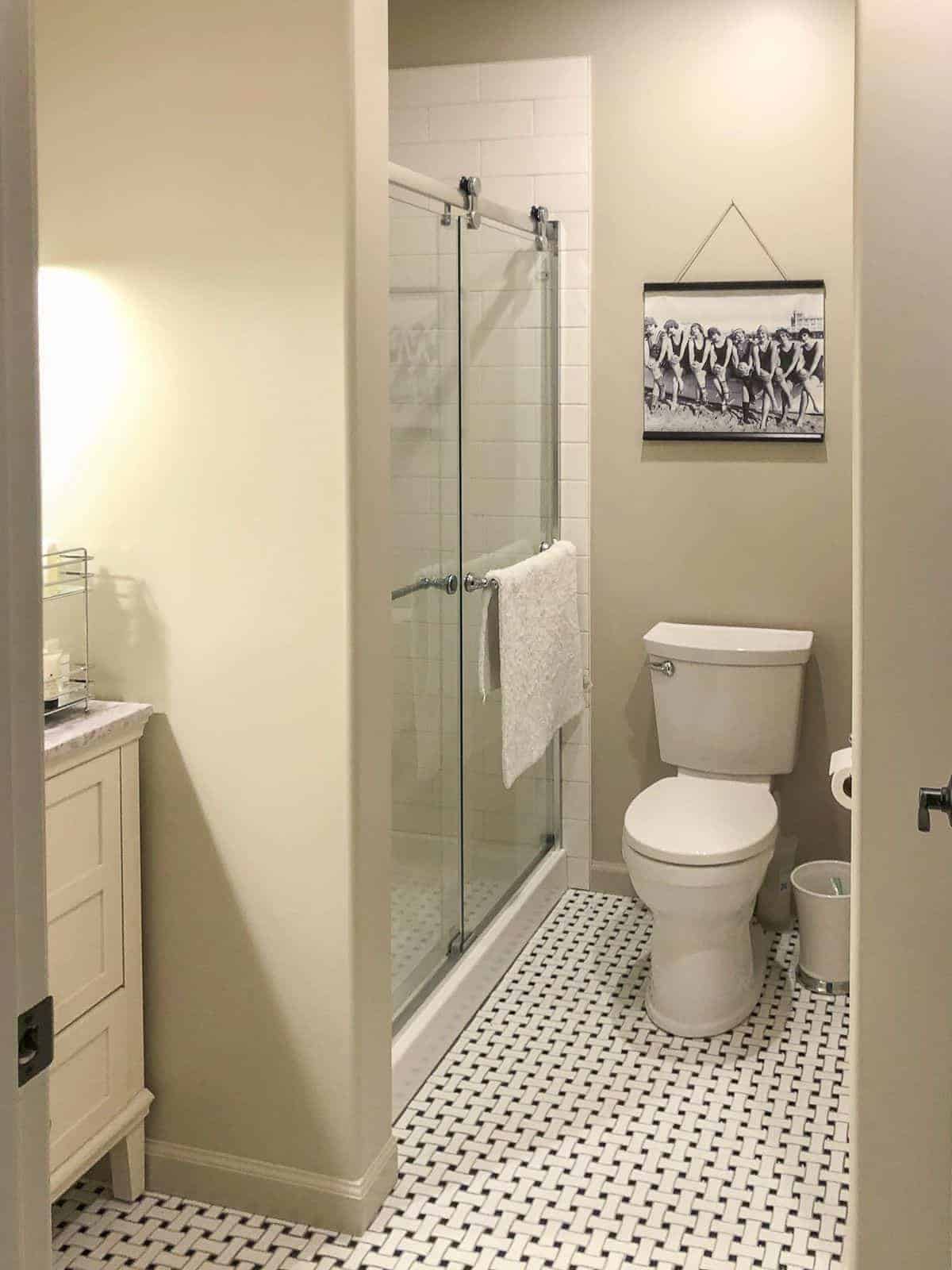 SW无障碍米色小浴室，黑色和白色的复古瓷砖地板。