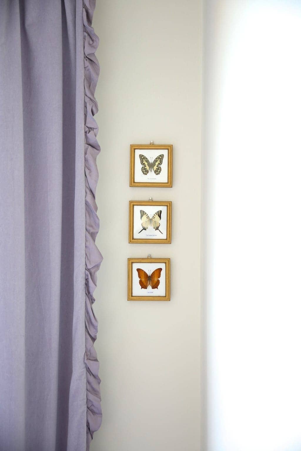 一个女孩的房间漆着奶油色的蝴蝶画和淡紫色的褶边遮光窗帘。