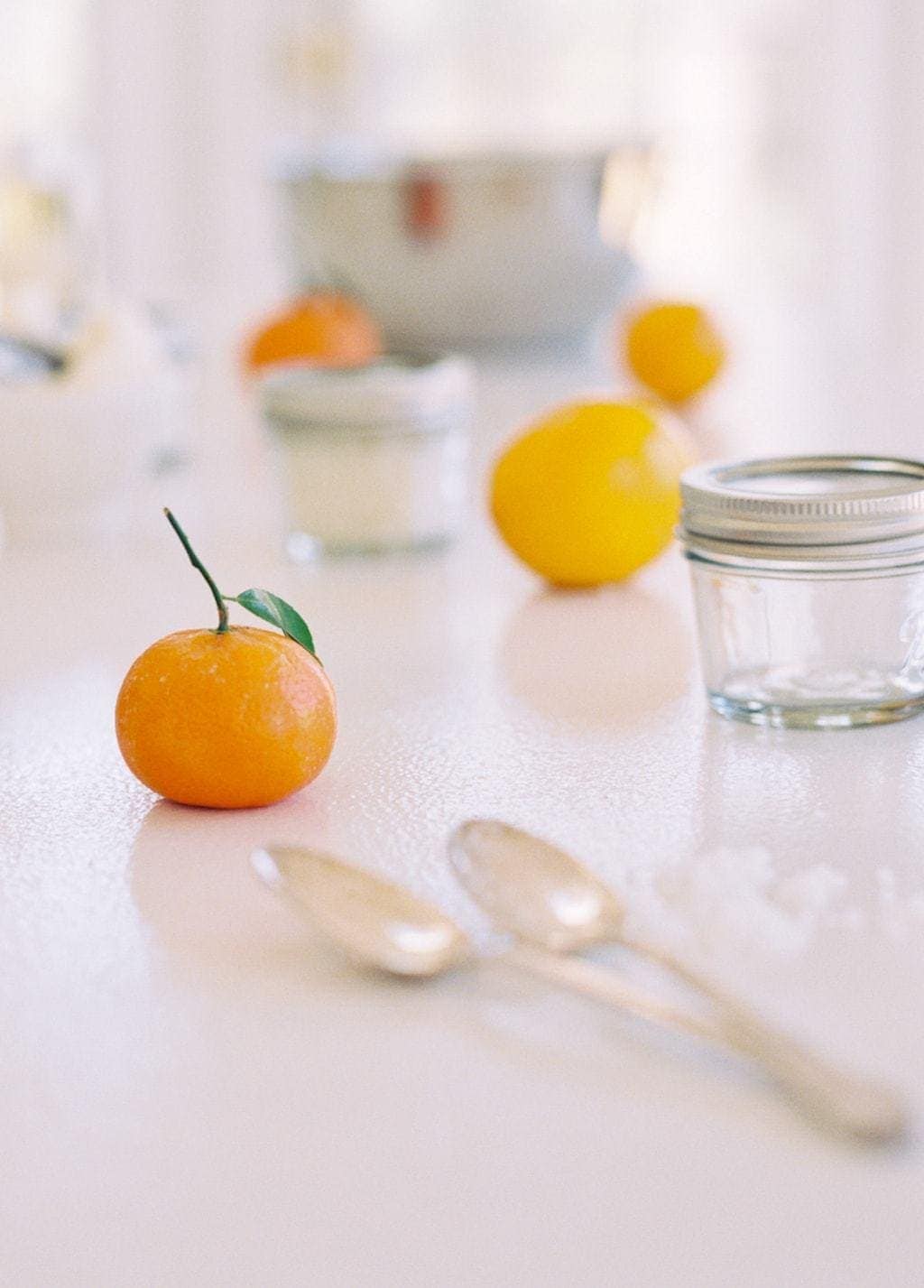 橙子丁香磨砂食谱成分放在白色表面上。
