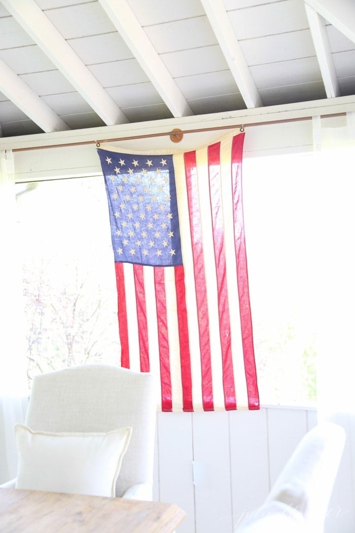 7月4日的窗帘杆上悬挂着一条美国国旗。