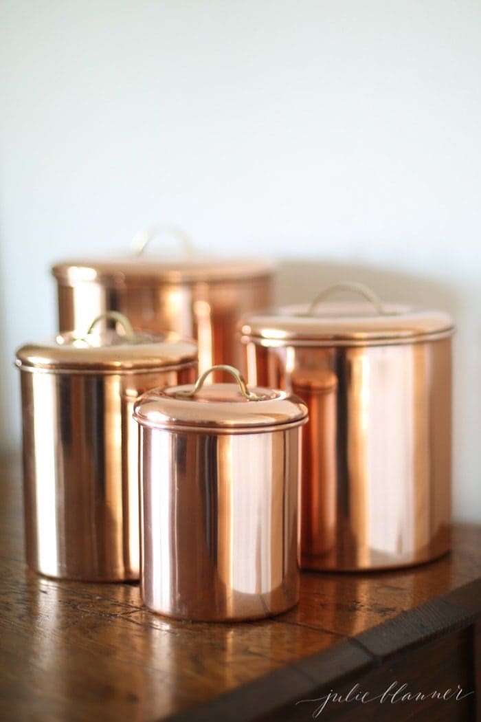 一套4个铜厨房罐在木桌子上