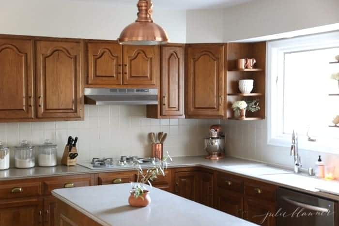 一个现代的厨房，有橡木橱柜和温暖的铜口音