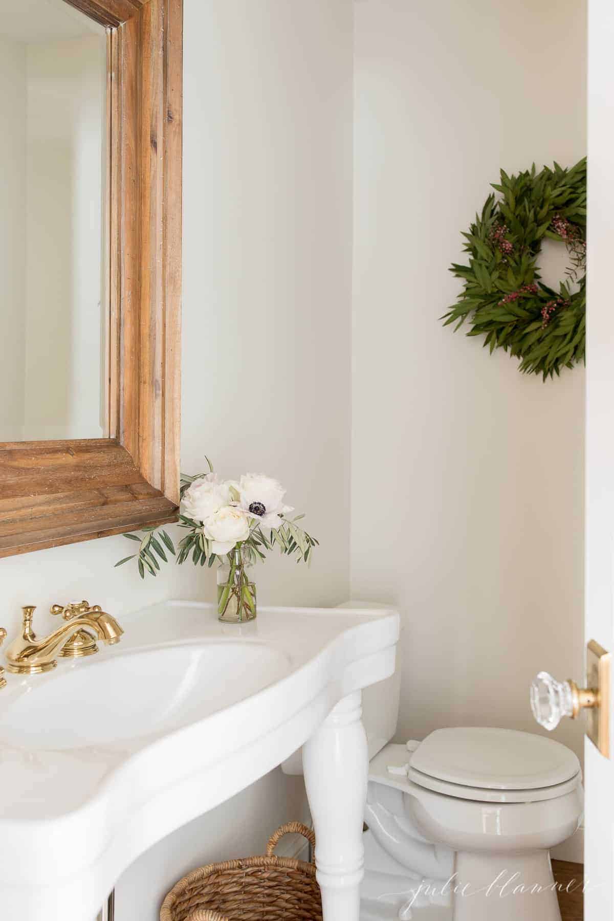 传统浴室，带有白色水槽镜子和圣诞花圈