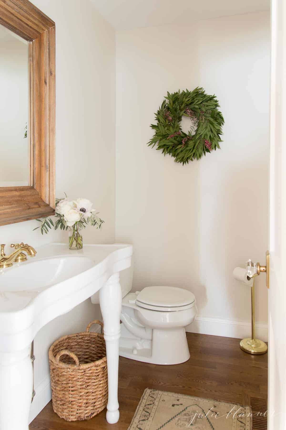 为圣诞节装饰的浴室，带有编织废物basket巴黎水槽和土耳其地毯