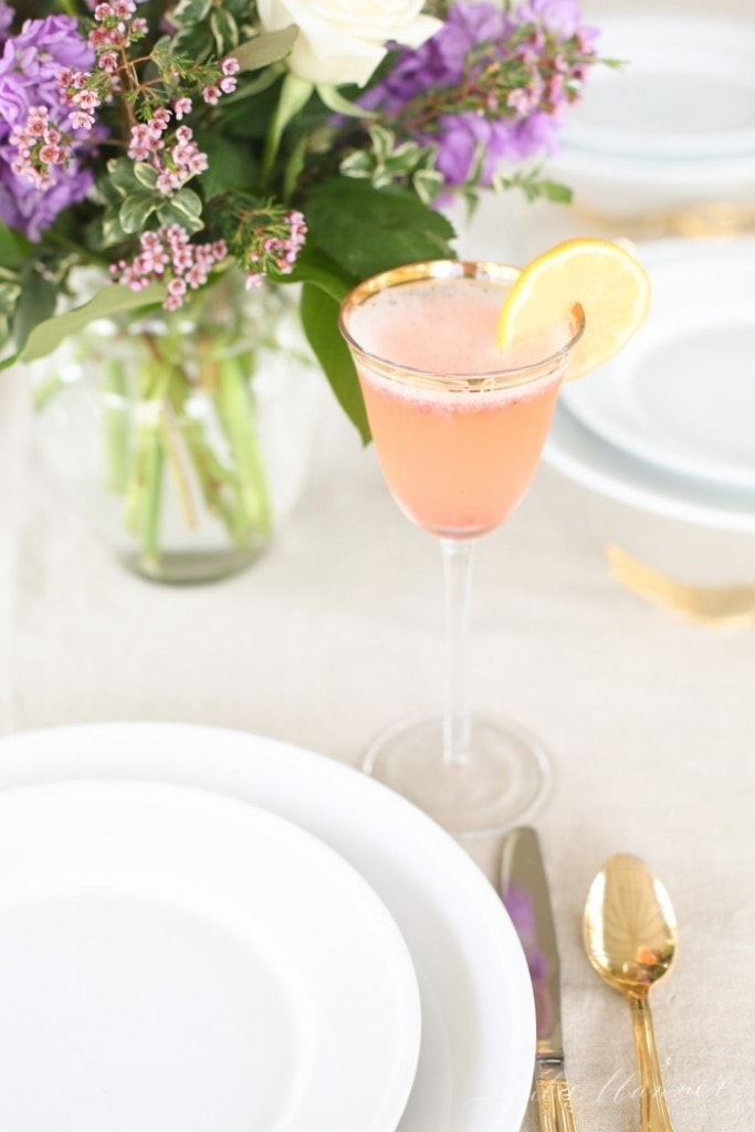 一份草莓夏季含羞草鸡尾酒，配以柠檬，放在餐桌上。