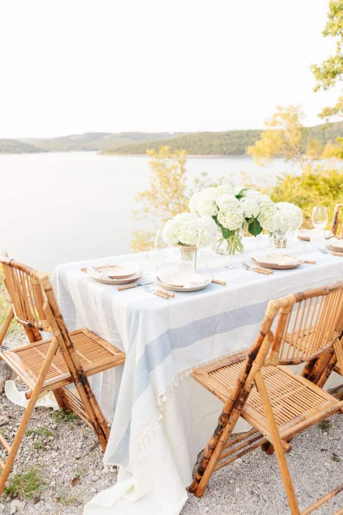 一张桌子设置了竹餐椅和水景观的户外餐饮。