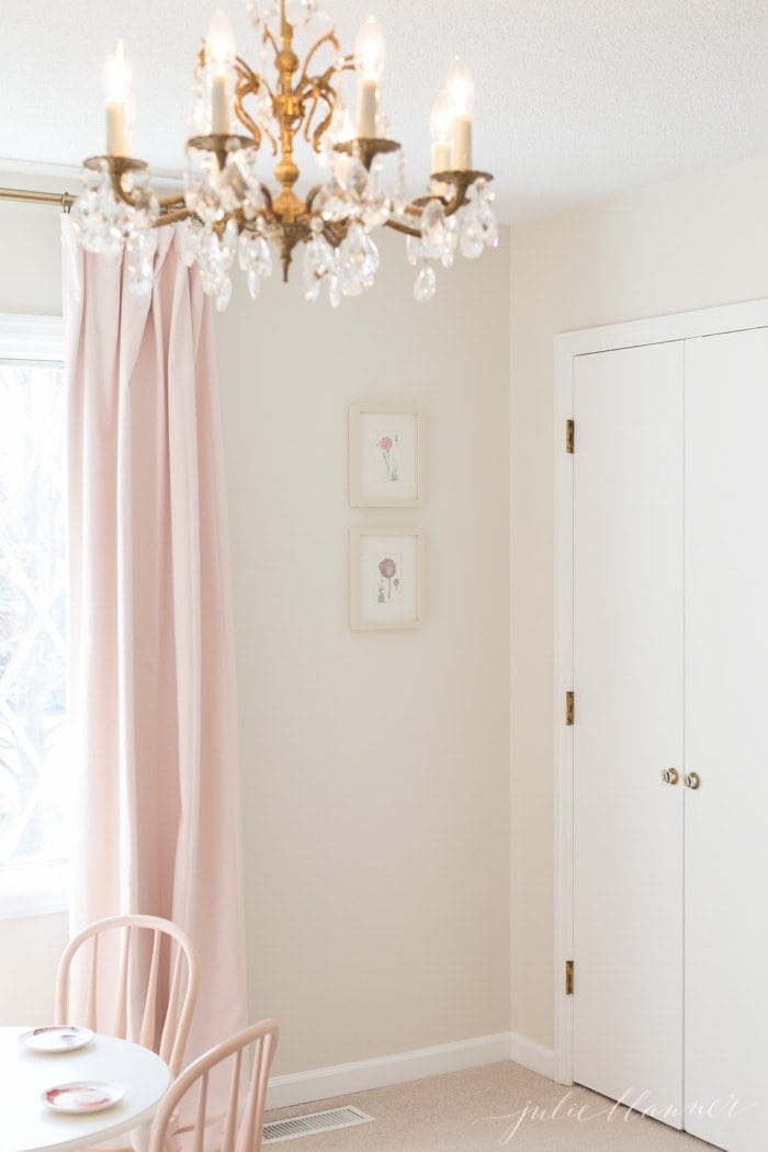 一个女孩的卧室，有粉色的遮光窗帘和金色的吊灯。