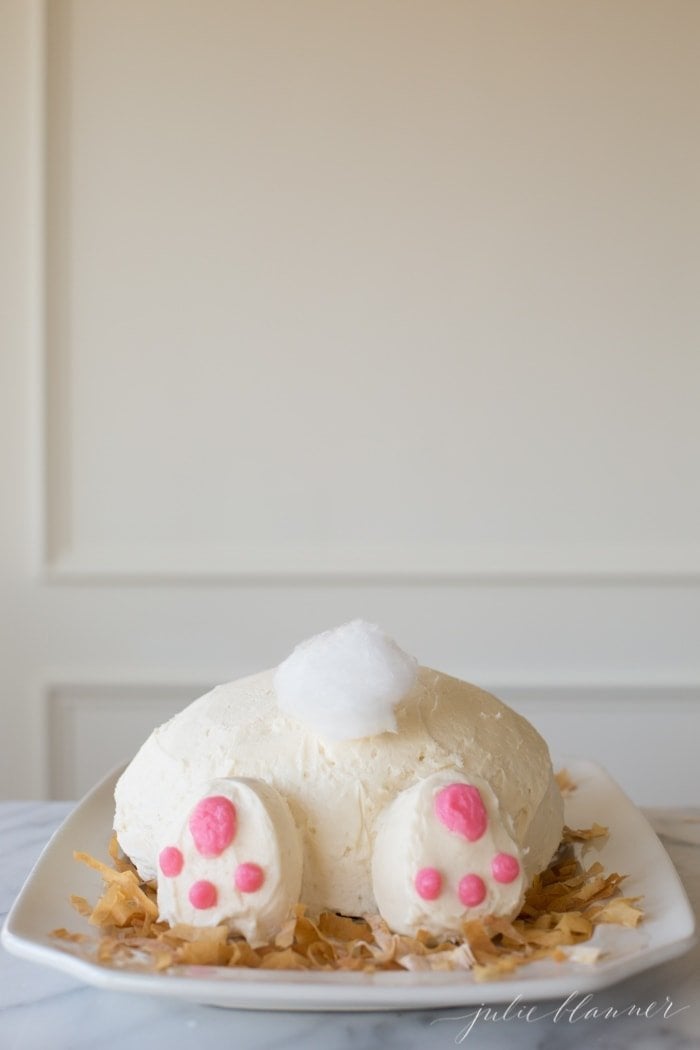 一个复古风格的兔子蛋糕，用棉花糖做成兔子尾巴，放在白色浅盘上。gydF4y2Ba