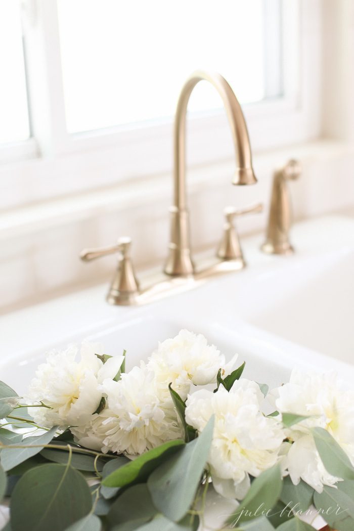 香槟青铜水龙头和原装瓷水槽里的鲜花