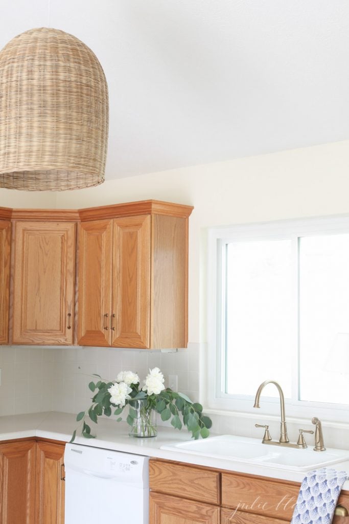 大型藤条吊坠为橡木橱柜的厨房增添了温暖的色彩和质感。