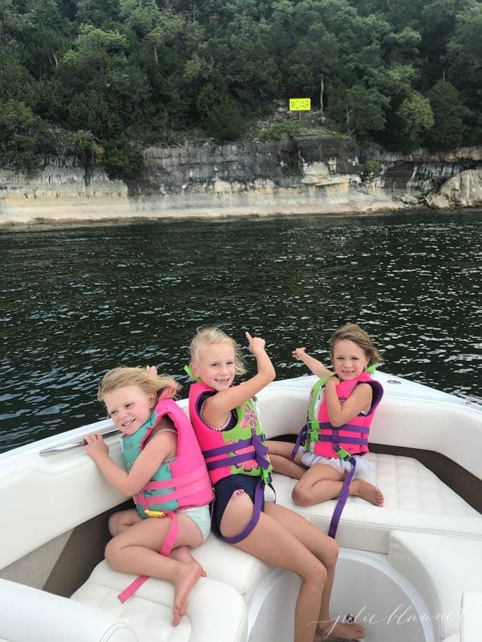 三个小女孩在桌岩湖的白色小船上，这是在密苏里州布兰森的一系列活动的一部分。