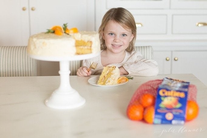 一个小女孩正在吃一片橘子蛋糕gydF4y2Ba