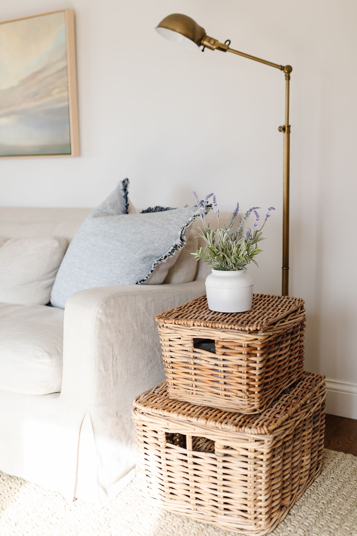一张亚麻沙发，茶几上有篮子，房间里漆着苏黎世白色