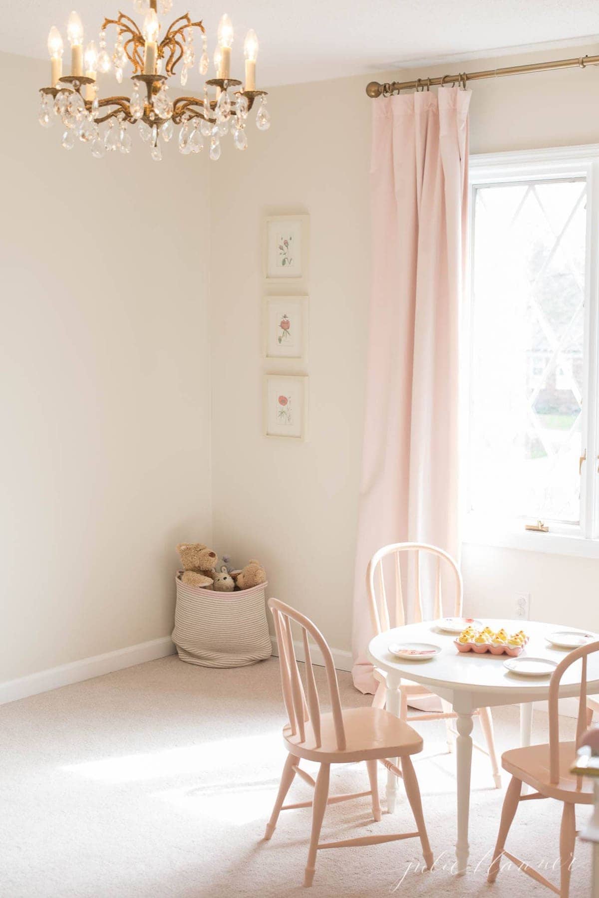 一个小女孩的房间在一个舒适的房屋中，带有天鹅绒窗帘和老式吊灯。
