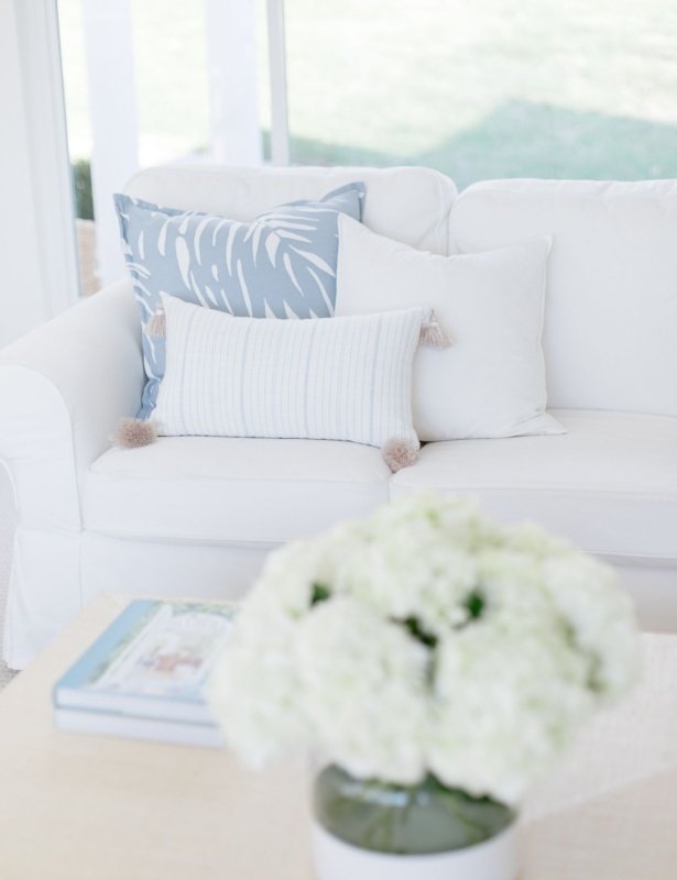 一个白色的客厅，带有白色沙发和沿海装饰