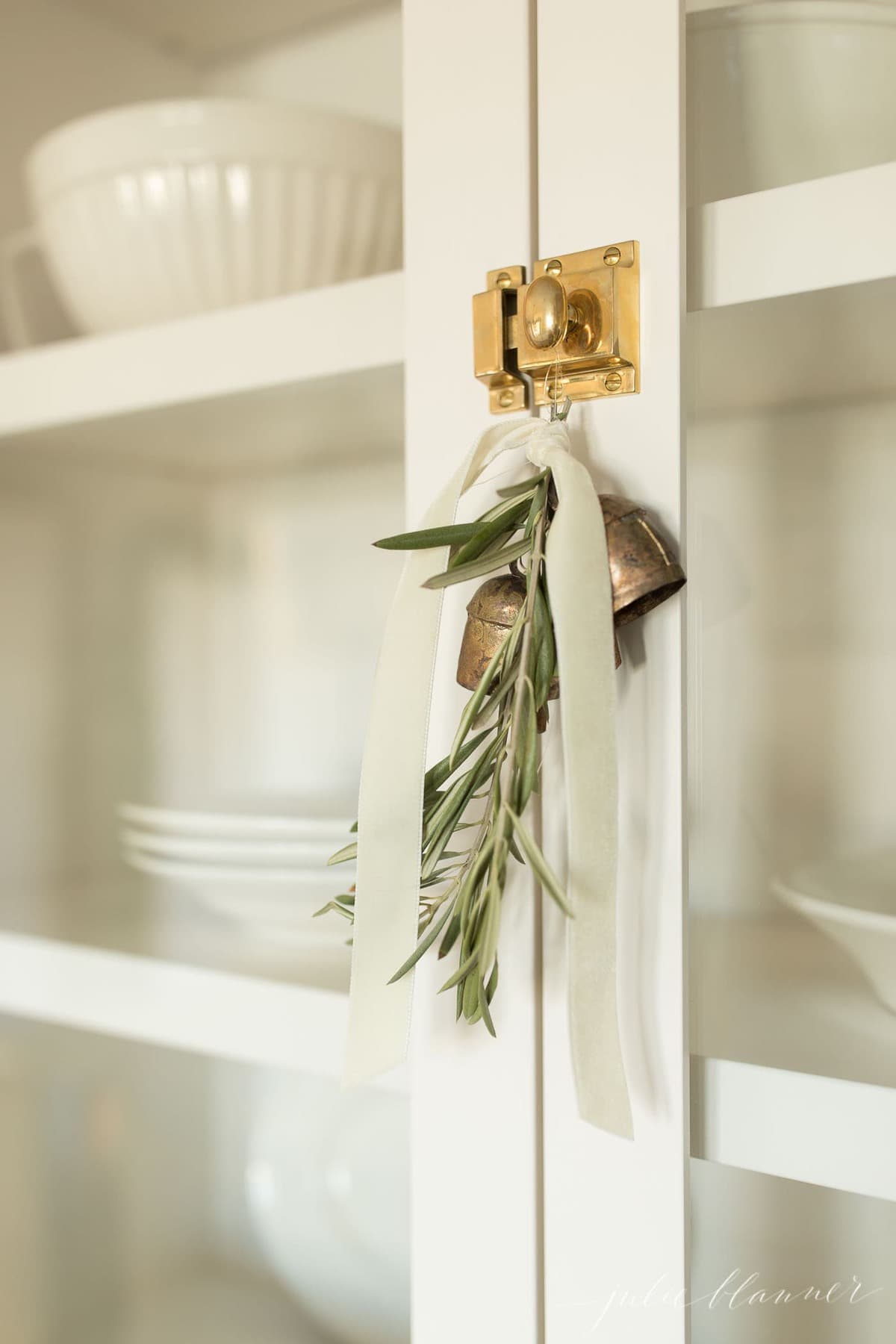 绿色植物，铃铛和天鹅绒丝带挂在厨房的橱柜