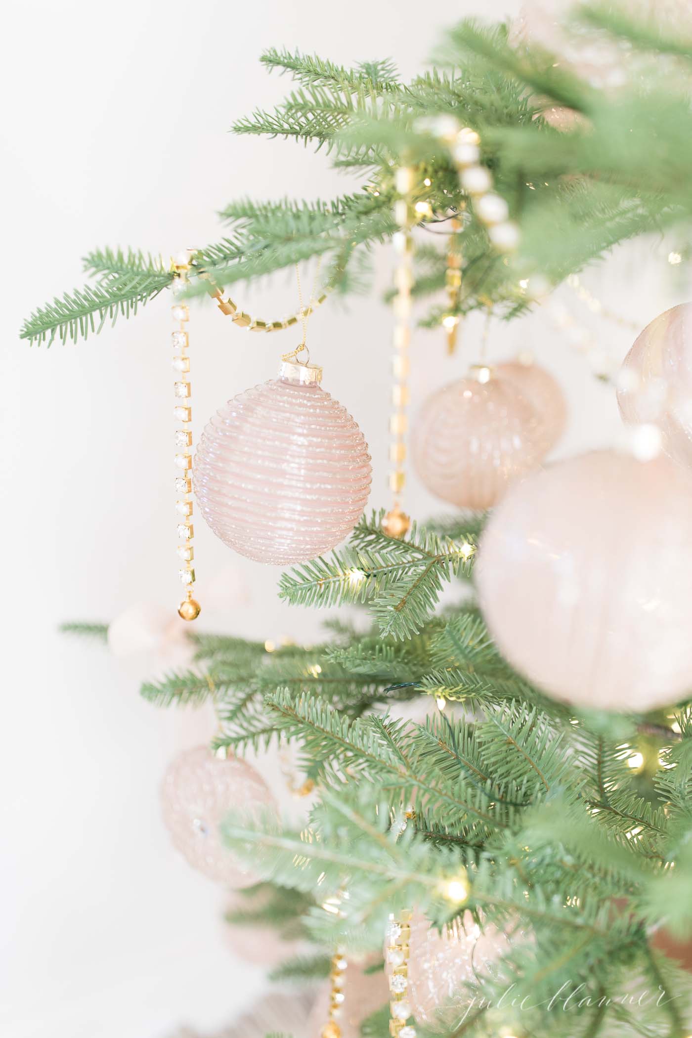 稀疏的圣诞树上装饰着金色和粉色的装饰品