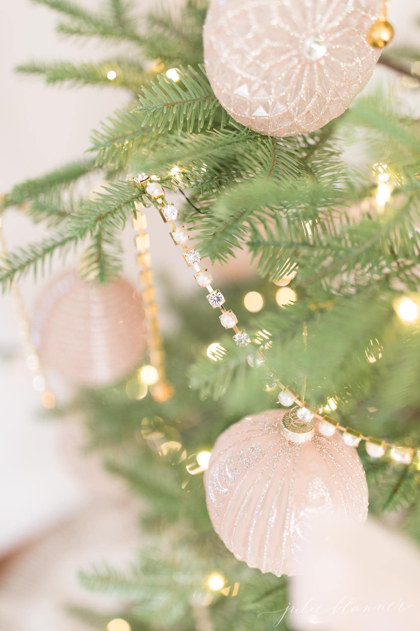 一棵稀疏的圣诞树，点缀着粉色和金色的饰品
