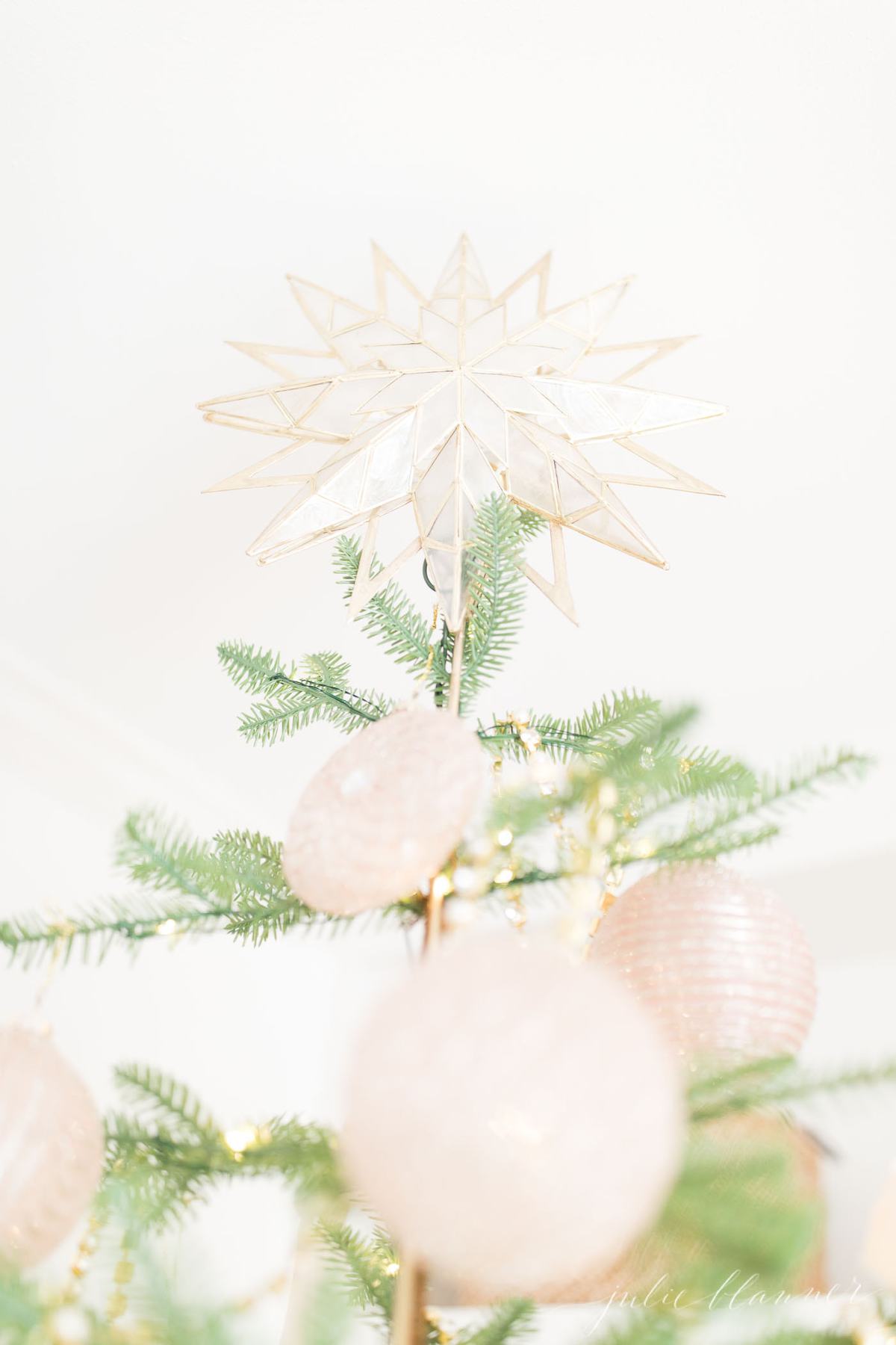 稀疏的圣诞树，粉红色的装饰品和金色的花环