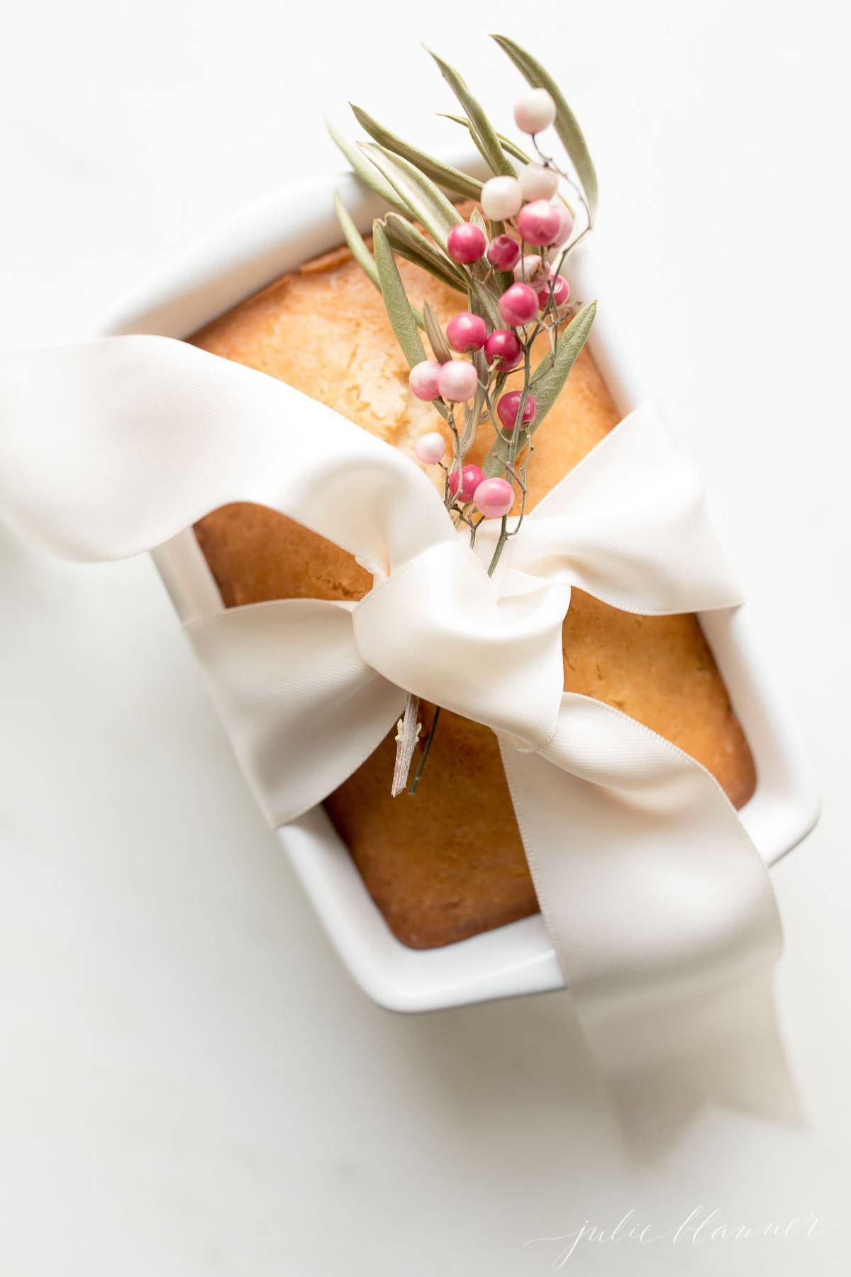 杏仁面包，白色的面包盘，象牙缎带和装饰浆果作为礼物gydF4y2Ba