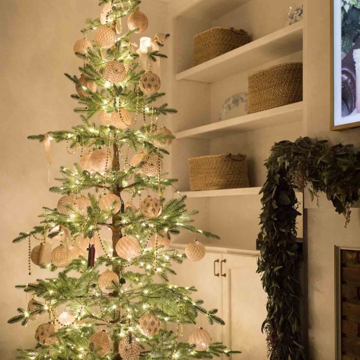 白色客厅里稀疏的圣诞树，晚上点亮