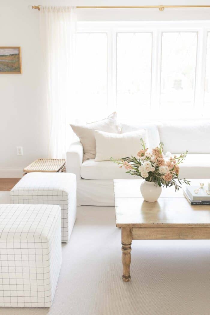 白色的客厅，木茶几上放着一瓶花。