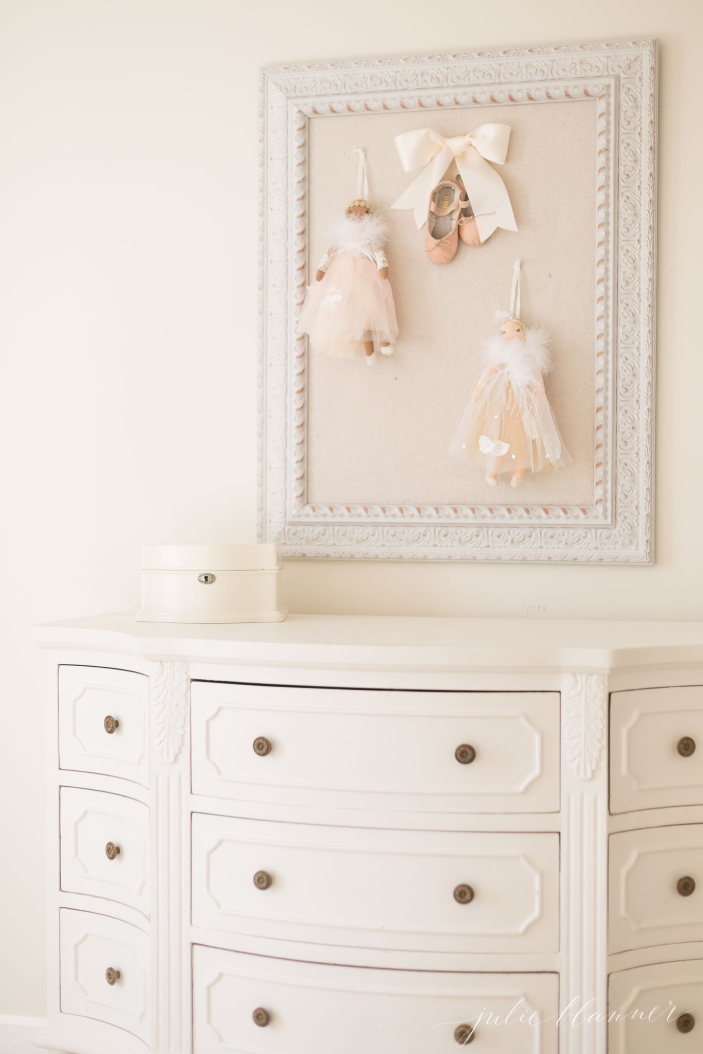 一个小女孩的卧室场景，白色的梳妆台和芭蕾细节的白色插销板。