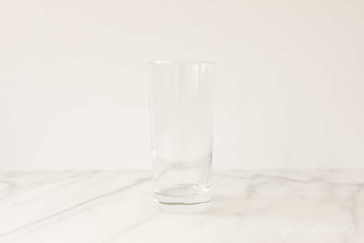 在白色大理石台面上细长的透明饮料玻璃。GydF4y2Ba