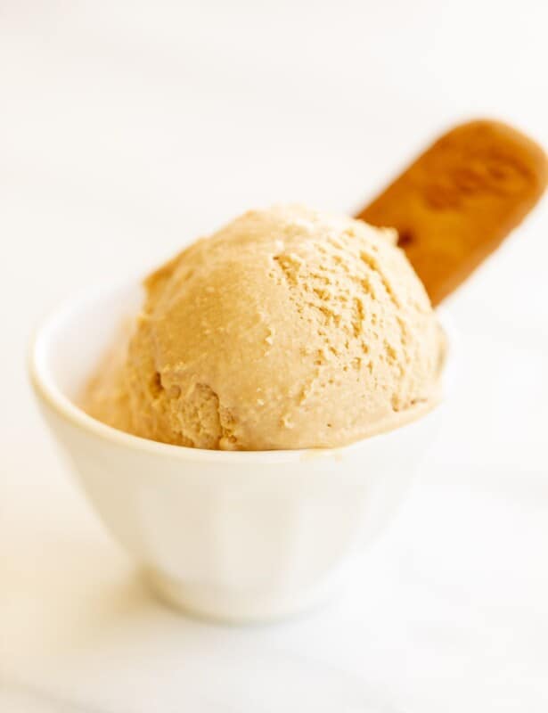 有曲奇饼黄油冰淇凌的两瓢的白色碗，在白色表面上。#cookiebuttericecream #speculoosicream