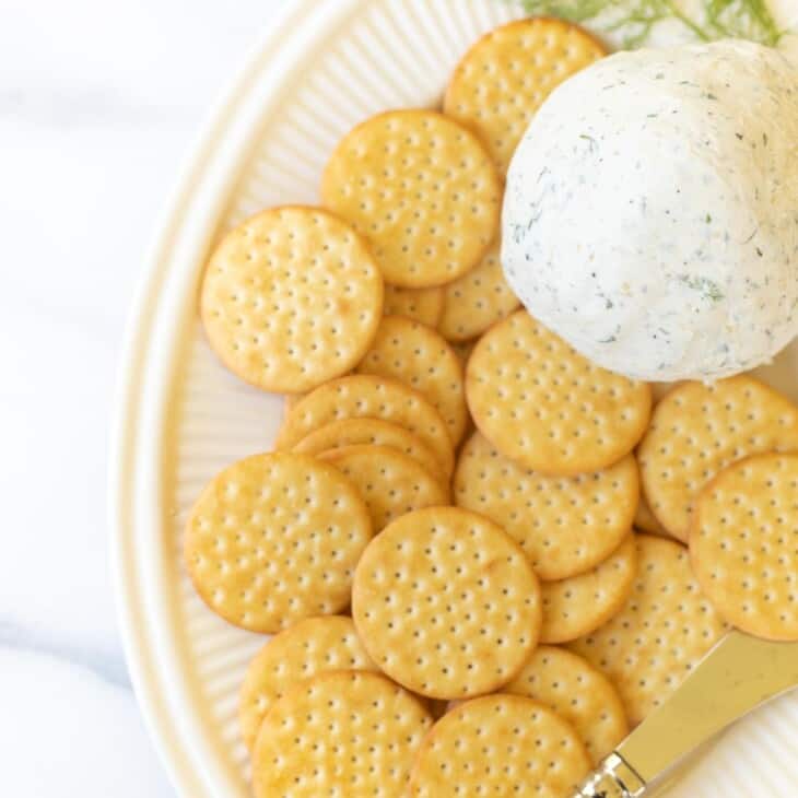 在一个奶油拼盘的Boursin乳酪球用薄脆饼干和乳酪吊具。#boursincheese.GydF4y2Ba