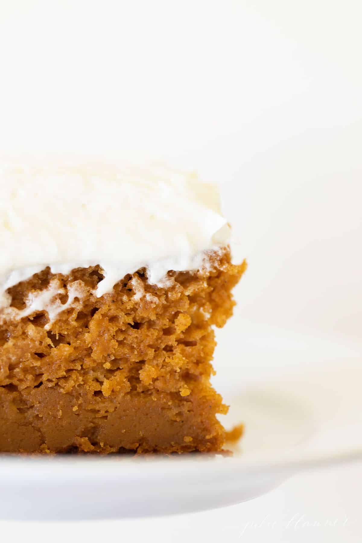 一张覆盖着奶油糖霜的南瓜蛋糕的特写。# pumpkincake # pumpkincakerecipegydF4y2Ba