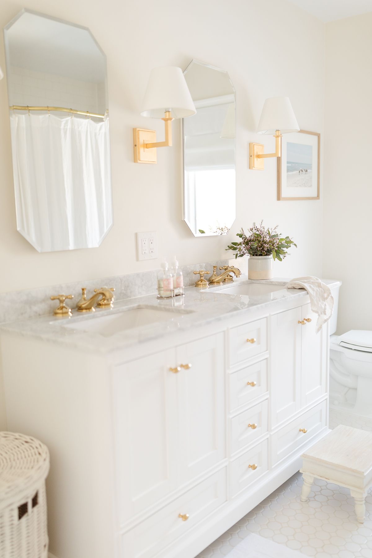 一个带有白色梳妆台和金色装置的水疗浴室